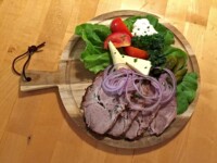 Tagesgericht - Kalter Braten mit Meerrettich, Essiggurke und Brot Tagesgericht - Kalter Braten mit Meerrettich, Essiggurke und Brot, serviert auf einem Holzbrett