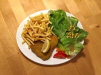 Gemüseschnitzel mit Pommes und Salatgarnitur Gemüseschnitzel mit Zitronenspalte, Pommes Frites und Salatgarnitur